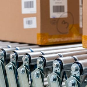 Cardboard shipping cartons moving along a warehouse conveyor system