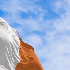 Irish national flag waving against a clear sky