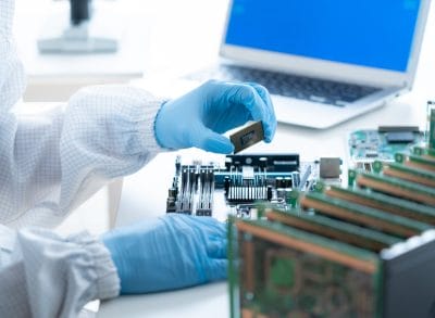 Engineers inspecting components in a cleanroom