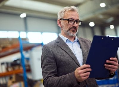 Manager reviewing supplier documentation in an industrial facility