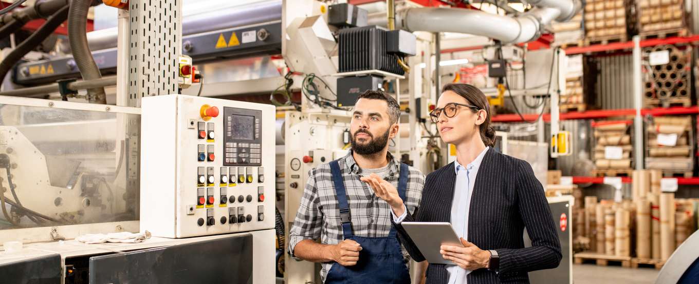Two specialists testing and discussing a component in a processing facility
