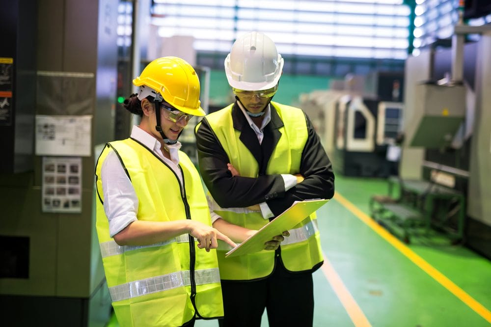 Two engineers reviewing a single quote document together in a plant