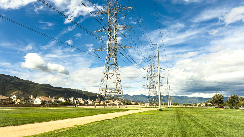 High-voltage transmission towers and power lines across a green field