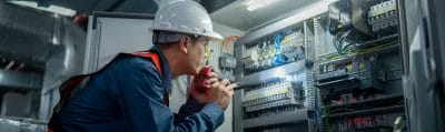 Technicians working inside an electrical control cabinet