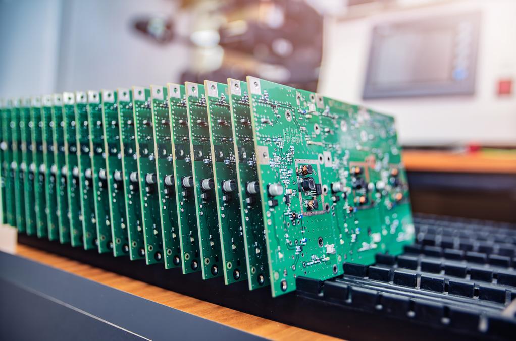 Electronic circuit boards stacked on a workbench in a production lab