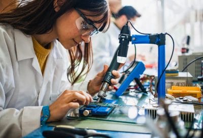 Engineers working together on circuit boards at a bench