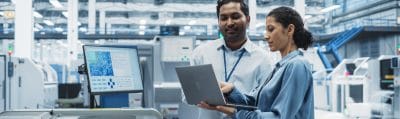 Engineer and manager reviewing circuit board production at an electronics factory