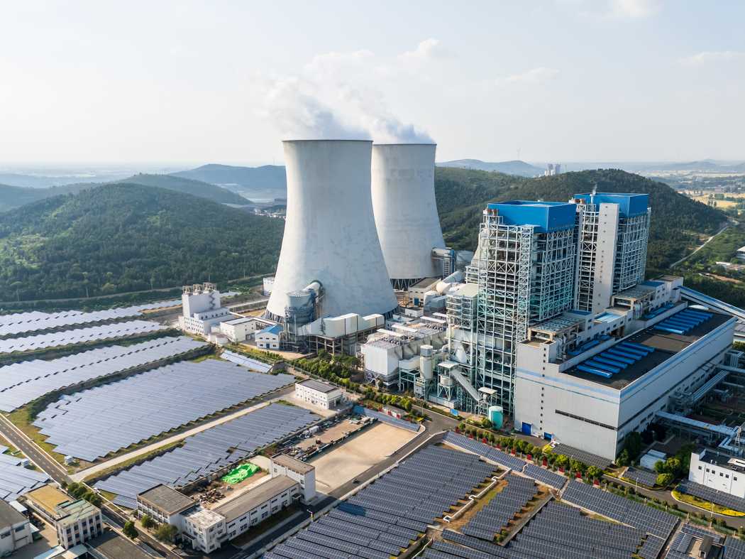 Aerial view of a thermal power plant with solar panels